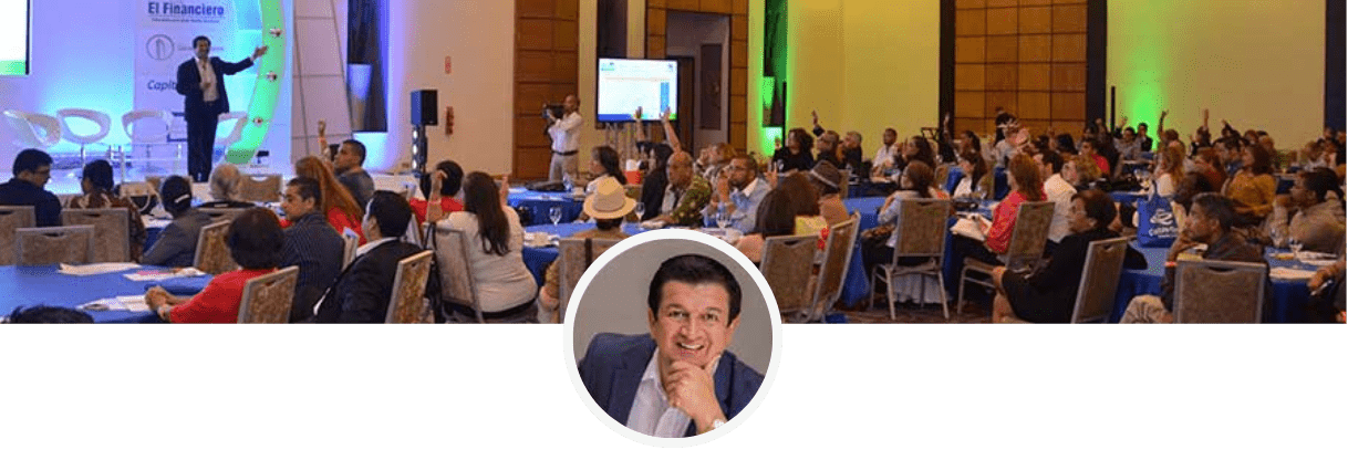 Fotografía de Enrique Núñez, fundador de FundaPymes y Meridyam Academy, frente a un salón lleno de asistentes levantando la mano para hacer consultas, en una de sus conferencias en Panamá. 